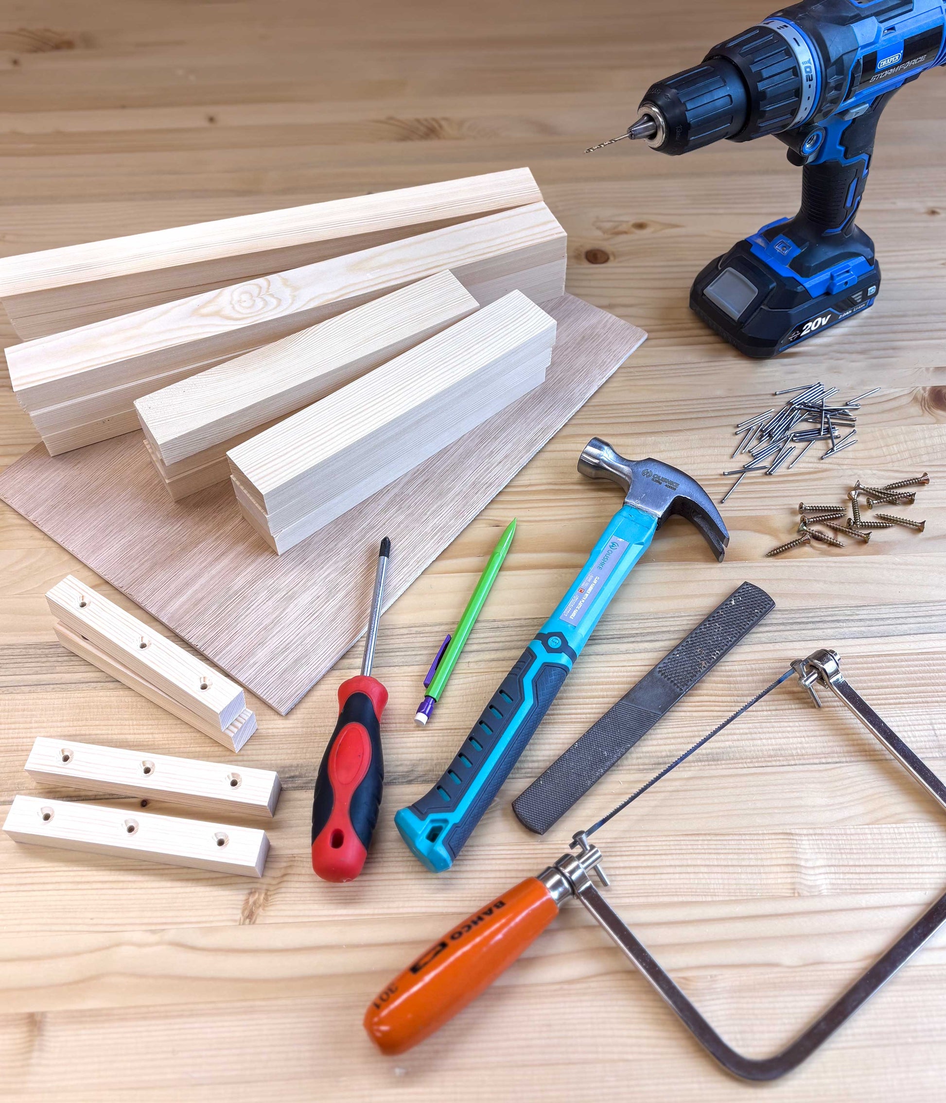 Apple crate project and woodworking tools including a drill, hammer, saw, and screws on a workbench at Ash and Co Workshops - beginners woodworking courses in Hampshire and Surrey UK