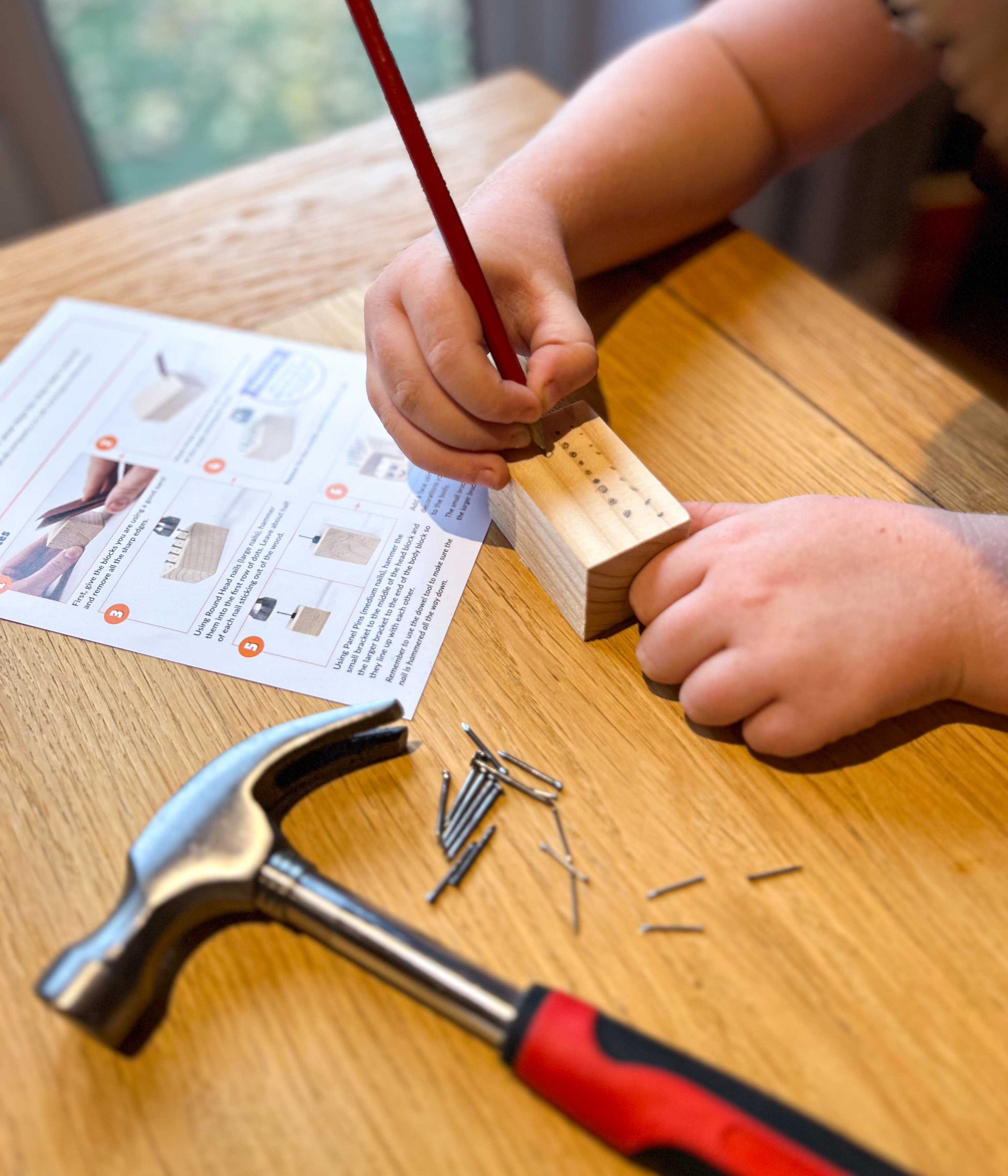 Young Woodworkers Hammer and Nails Projects - Make-at-home woodwork kit for kids - Using the pencil to mark out the woodworking project.