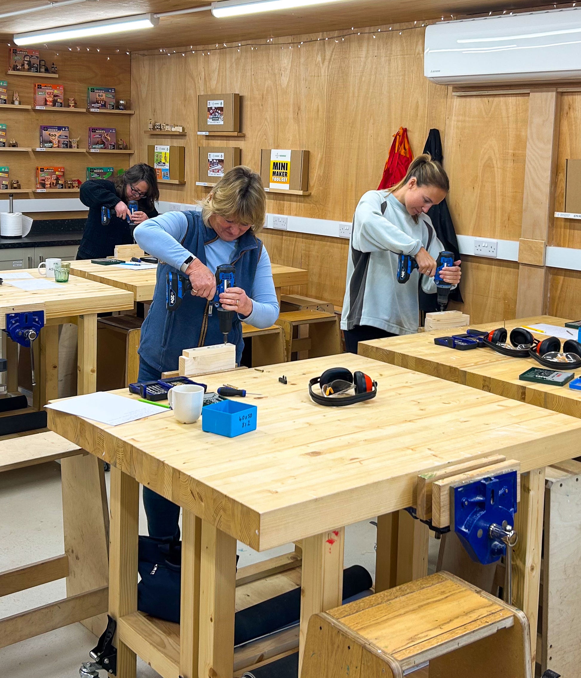 Participants learning practical DIY skills using drills in workshop