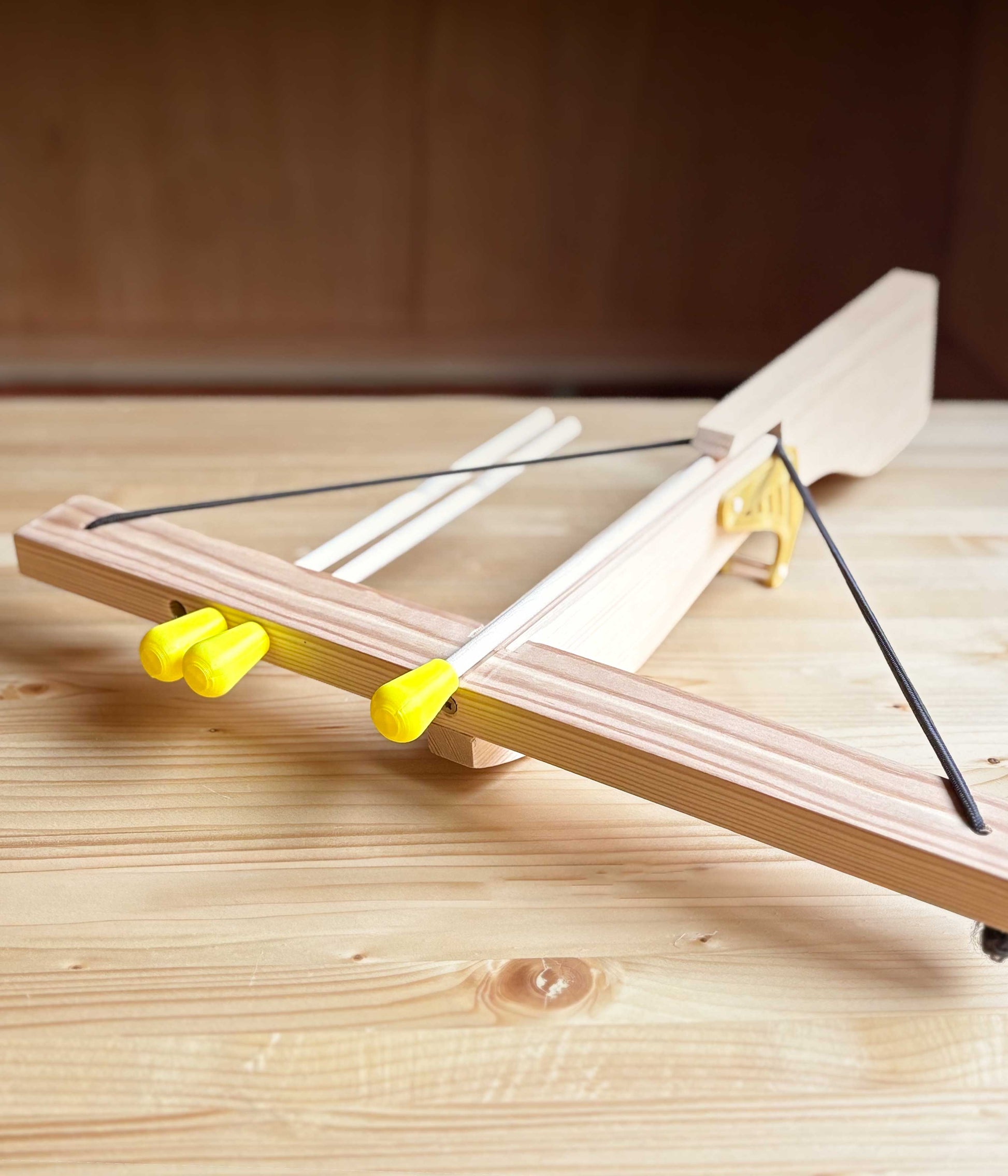 Wooden toy crossbow on a wooden surface in Ash and Co Workshops