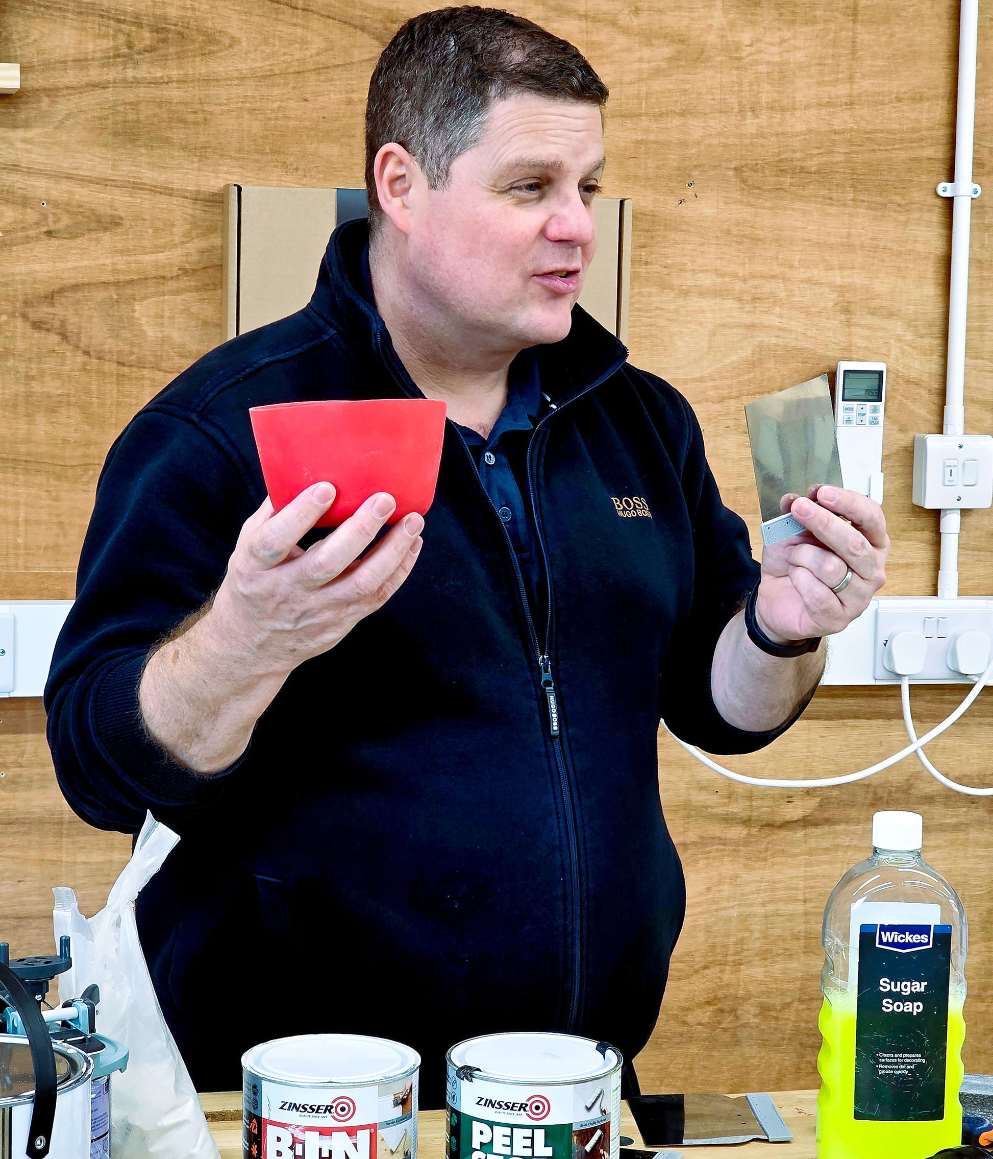 Tutor demonstrating decorating tools used for wall preparation and filling on a beginner DIY decorating course, including fillers and preparation equipment.